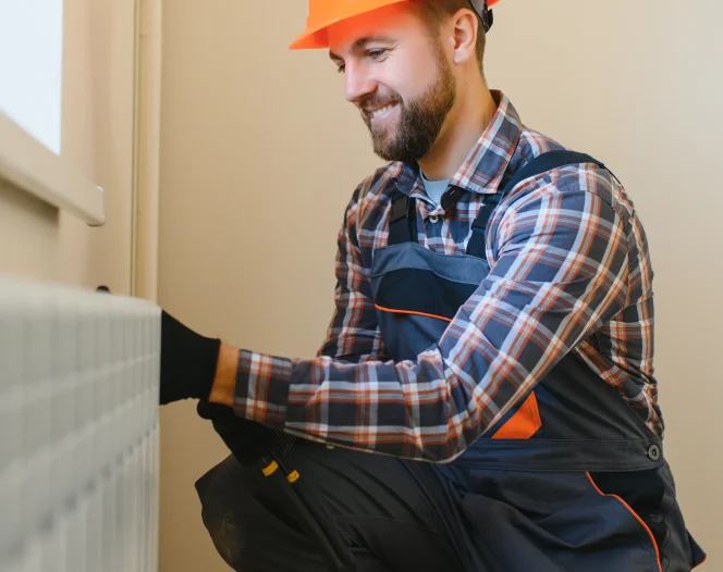 plumber man is blocking repairs radiators of heating battery in apartment tap photo 1